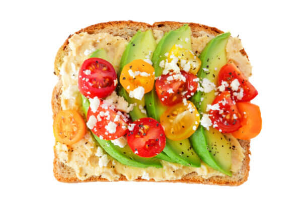 Avocado toast with hummus and tomatoes isolated on white